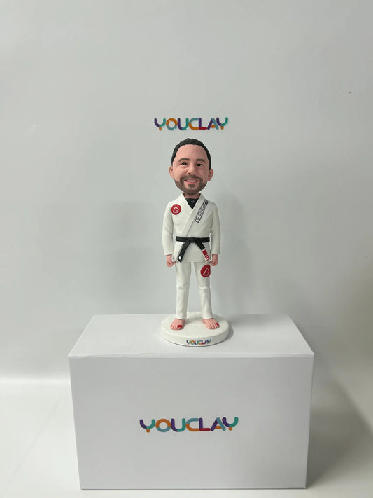 Custom bobblehead of a bearded man in a white jiu-jitsu gi with a black belt, standing barefoot