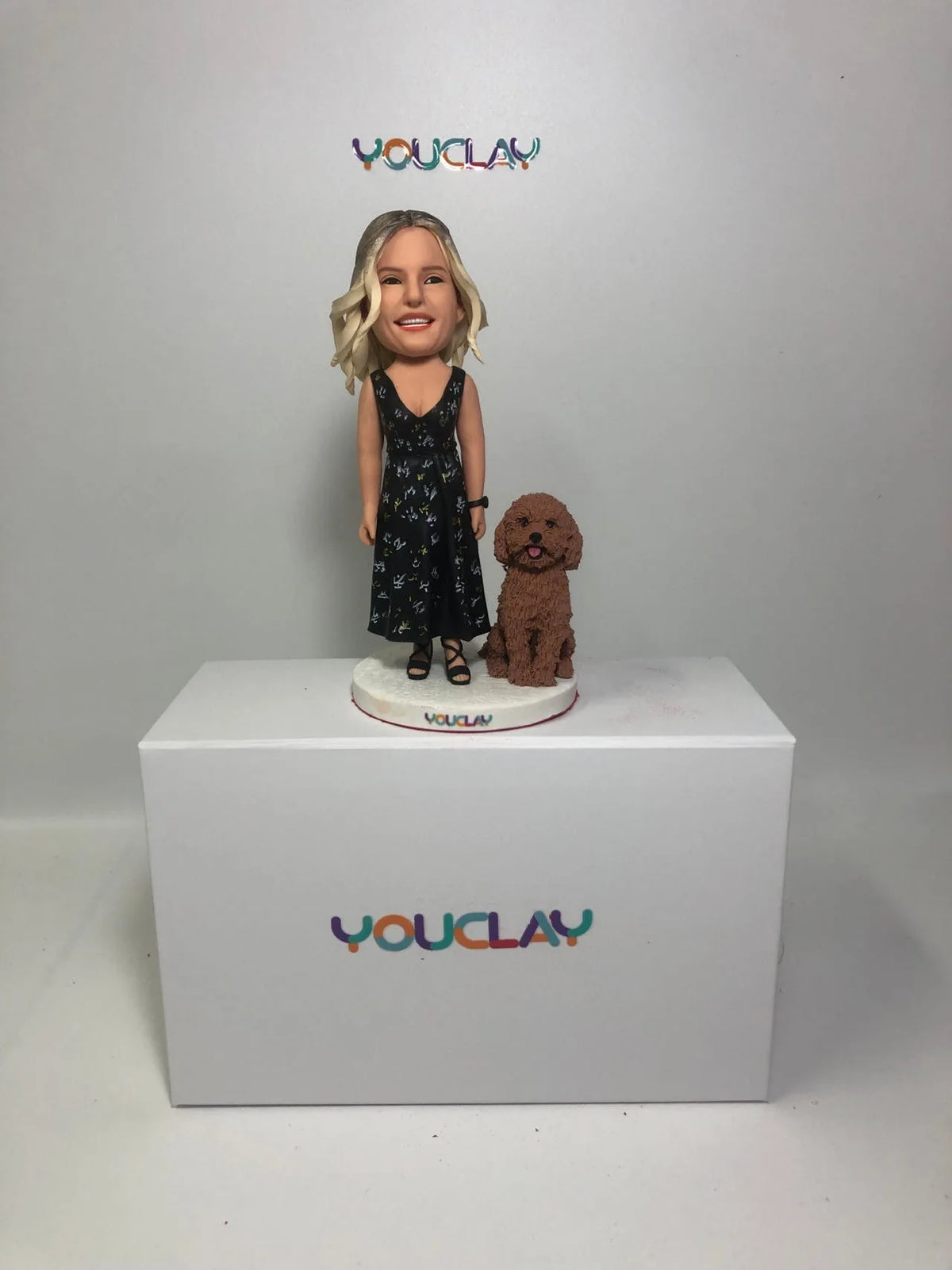 Woman in a black floral dress standing next to her curly brown poodle, a person-and-pet custom bobblehead