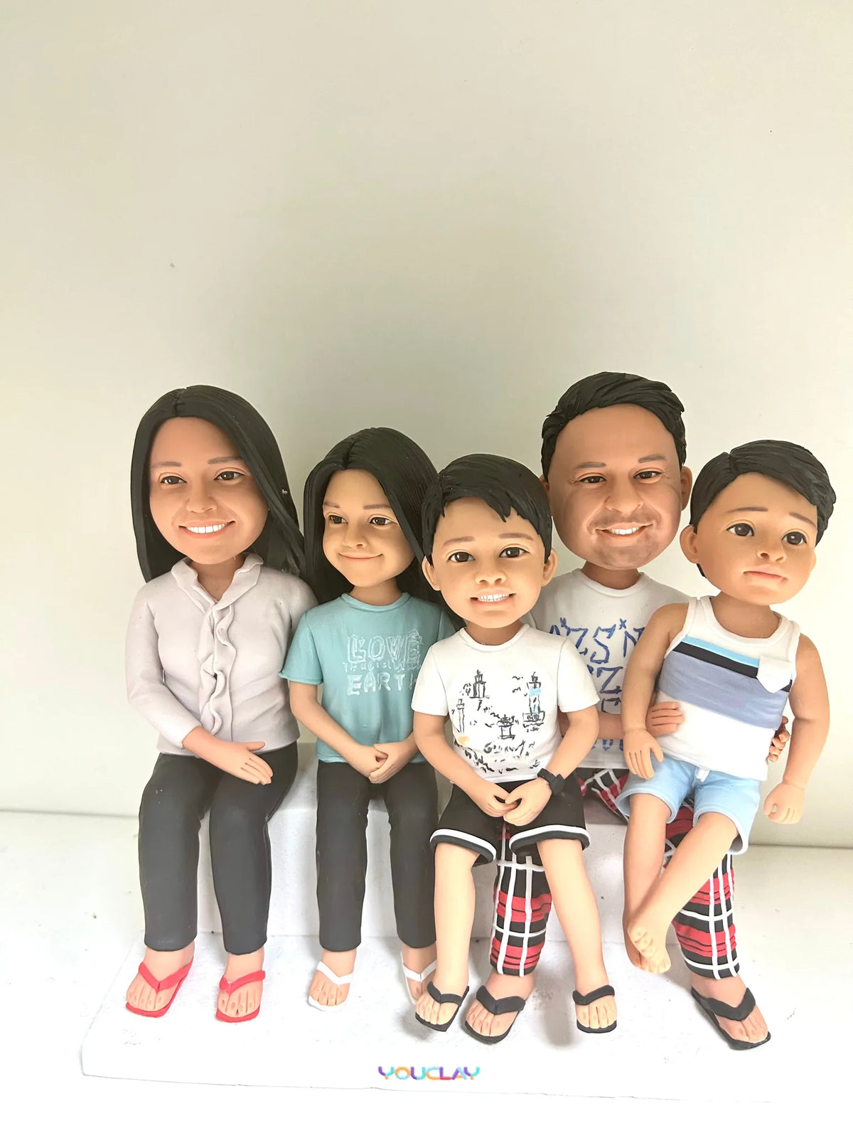Family of five sitting in a row in flip-flops and shorts, a relaxed custom bobblehead scene