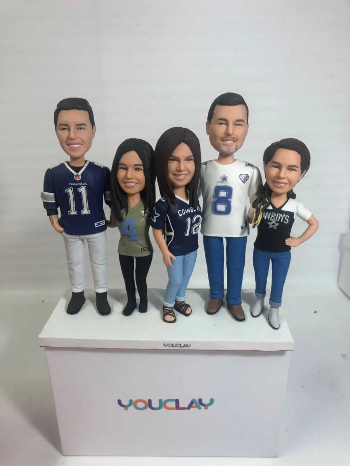 Five Dallas Cowboys fans in numbered jerseys, a family set of custom bobbleheads