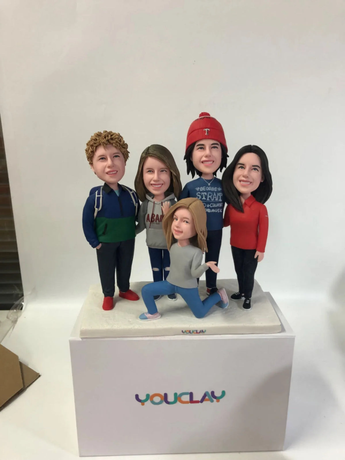 Family of five in winter wear, one kneeling in front, a festive custom bobblehead group