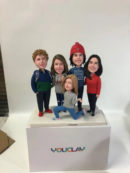 Family of five in winter wear, one kneeling in front, a festive custom bobblehead group