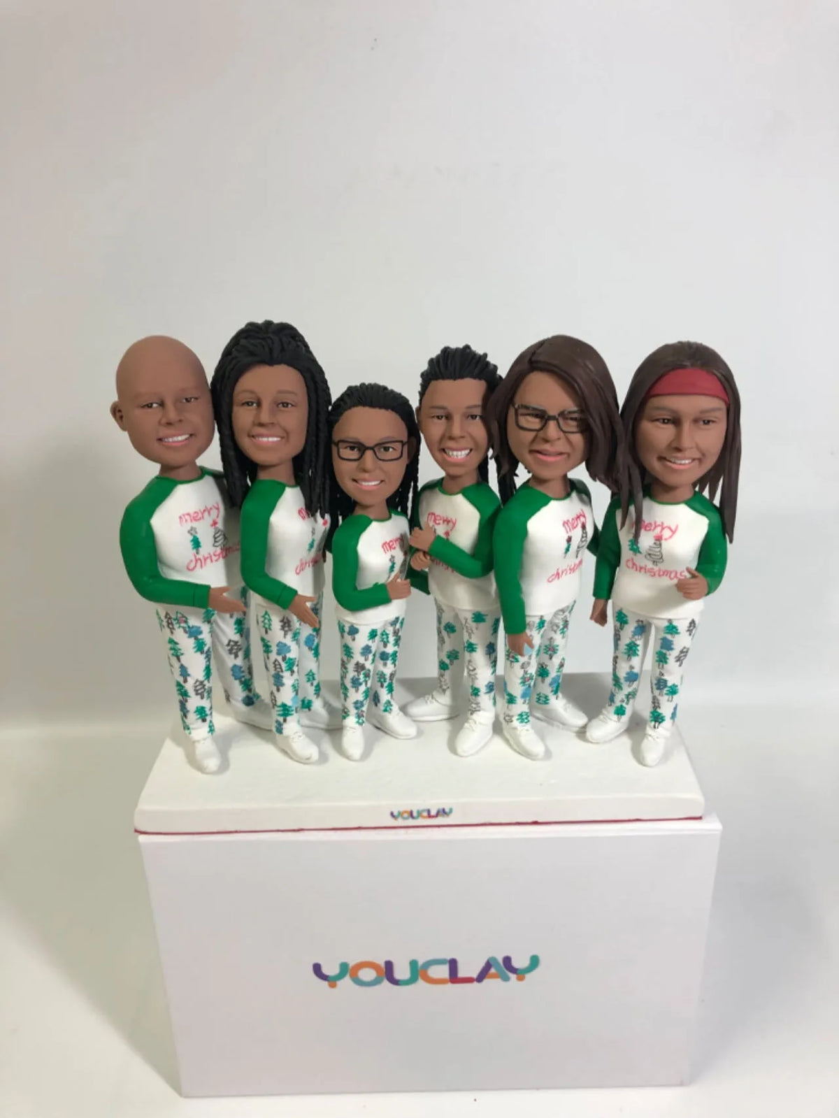 Six friends in matching green and white Christmas pajamas, a holiday custom bobblehead set
