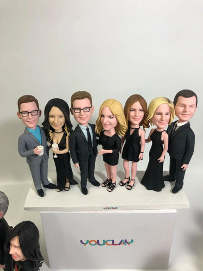 Seven friends in black evening wear with one man in a gray suit, a party-ready clay figurine group