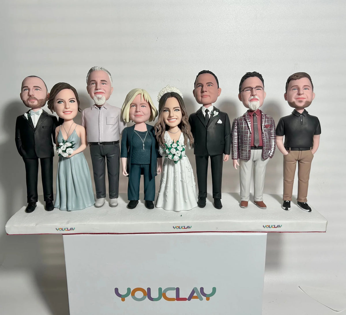 Eight-person wedding party: bride, bridesmaid in blue, and men in suits and casual shirts